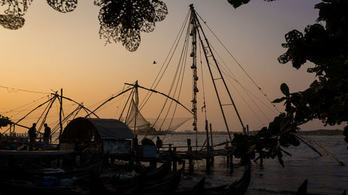 Boats moored at harbor during sunset