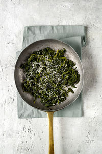 Buttered spinach in a pan with handle.