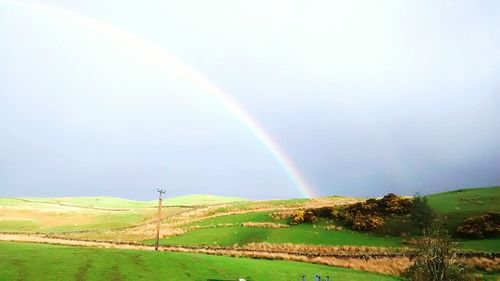 Scenic view of grassy field against cloudy sky