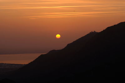 Scenic view of silhouette mountains against romantic sky at sunset