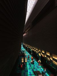 Illuminated walkway amidst buildings at night