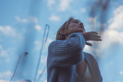 Low angle view of woman dancing against sky