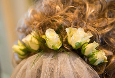 Close-up of bride hair with roses on shoulder