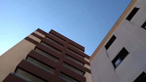 Low angle view of office building against blue sky