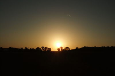 Silhouette landscape against clear sky during sunset