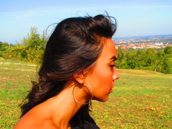 Close-up portrait of a beautiful young woman lying on land