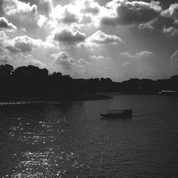 Scenic view of river against cloudy sky