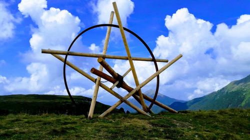 Metallic structure on field against sky