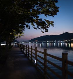 Pier over lake against sky at night