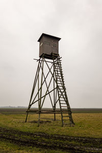 Lifeguard hut on field against sky