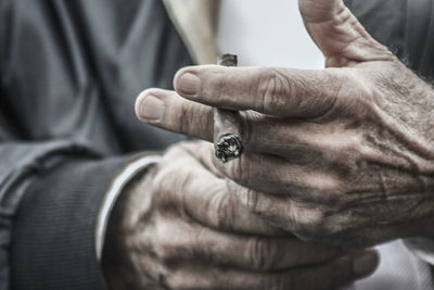 Mid section of man holding cigarette