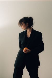 Young woman standing against wall