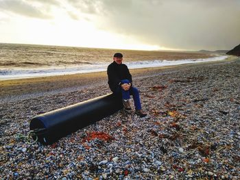 Full length of man standing at beach against sky