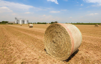 Hay bales on field against sky