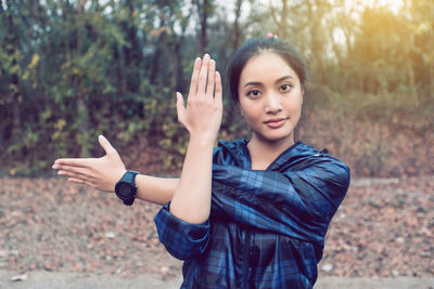 Portrait of young woman exercising at park