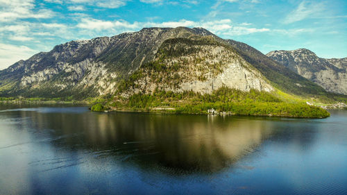 Scenic view of lake by mountains against sky