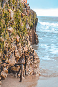 Rock formation on beach against sky