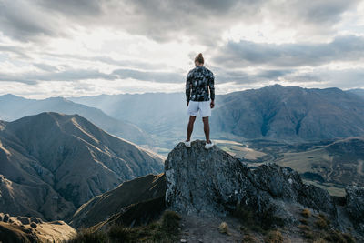 Rear view of man standing on cliff