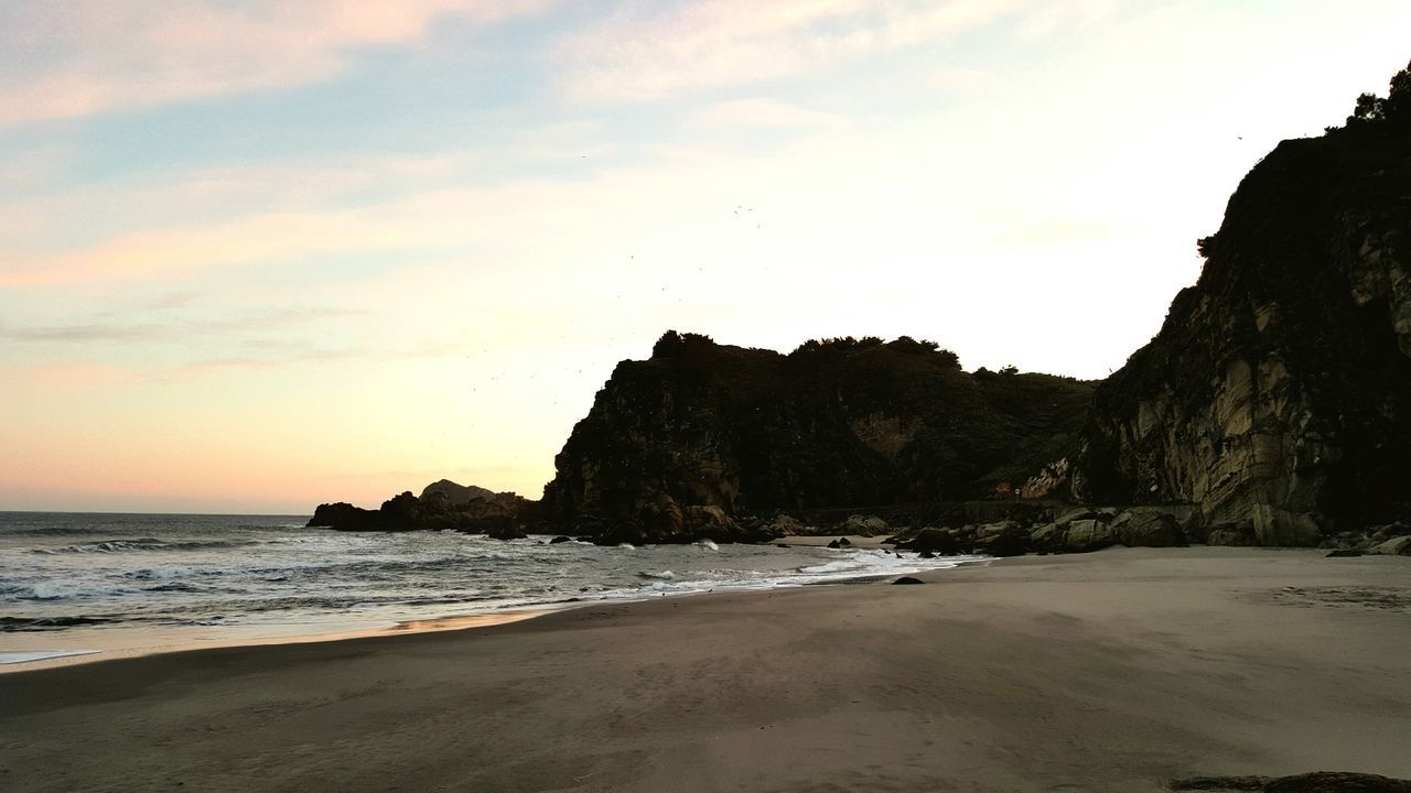 sea, beach, water, scenics, shore, tranquil scene, beauty in nature, sky, tranquility, horizon over water, rock formation, rock - object, sand, nature, coastline, sunset, cliff, wave, idyllic, surf