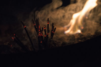 Close-up of incense sticks at night