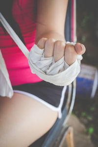 Midsection of woman wrapping bandage in hand