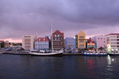 Boats in river with city in background