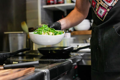 Midsection of man preparing food in kitchen