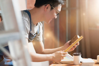 Side view of woman looking at camera on table