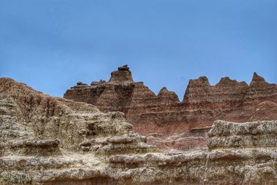 Low angle view of rock formation against clear blue sky