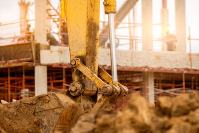 Bucket of backhoe. digger parked at construction site. bulldozer on blur building under construction 