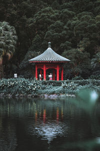 Built structure by lake against trees