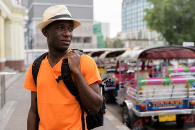 Man wearing hat standing on street in city