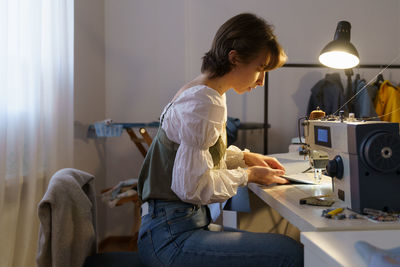 Tailoring business, young fashion designer work in studio. female sew clothes on sewing machine