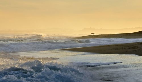 Scenic view of beach against sky during sunset