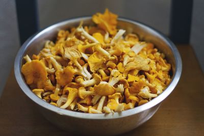 Close-up of fresh edible mushrooms in bowl on table