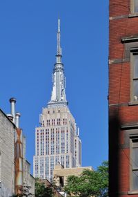 Low angle view of buildings against clear blue sky