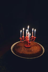 Close-up of lit candle in dark room