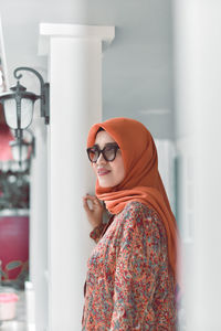 Portrait of young woman wearing sunglasses standing outdoors