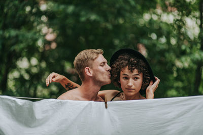 Portrait of shirtless man with baby outdoors