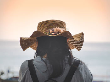 Rear view of woman against sky during sunset