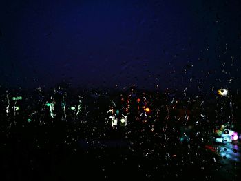 Close-up of illuminated water against sky at night