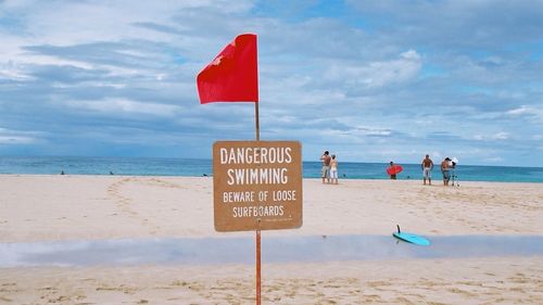 Warning sign on sandy beach