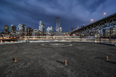 View of bridge and buildings against cloudy sky