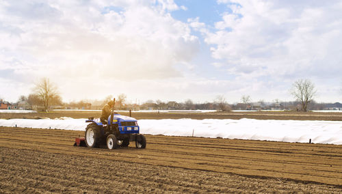 Farmer on a tractor with milling machine loosens, grinds and mixes soil. loosening the surface