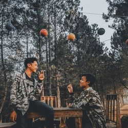 People looking at plants against trees