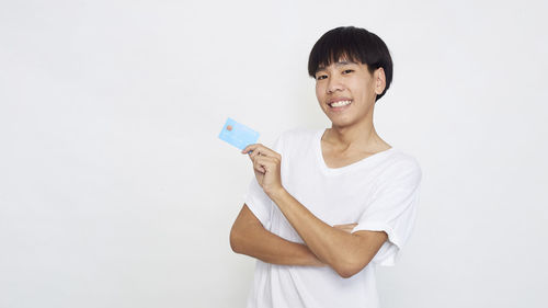 Portrait of smiling young woman against white background