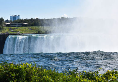 Scenic view of waterfall against sky