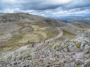 People on mountain against sky