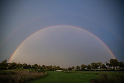 Rainbow over field against sky