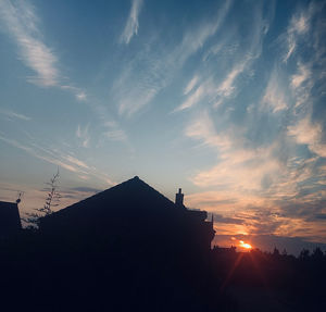 Low angle view of silhouette buildings against sky during sunset